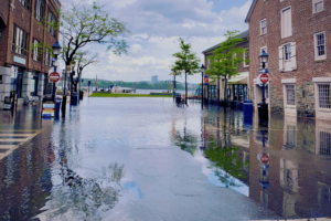 image shows street flooding near river with businesses closed